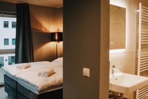 a hotel room with a bed and a sink at LA vie Hotel Landshut in Landshut