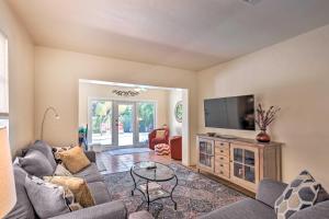 a living room with a couch and a flat screen tv at Tranquil West Palm Beach Getaway Walk to Beach! in West Palm Beach