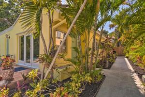 una casa amarilla con palmeras delante en Tranquil West Palm Beach Getaway Walk to Beach! en West Palm Beach