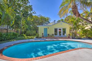 a swimming pool in front of a house at Tranquil West Palm Beach Getaway Walk to Beach! in West Palm Beach