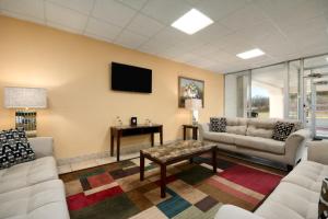 a living room with couches and a tv on a wall at Days Inn by Wyndham Shelby in Shelby