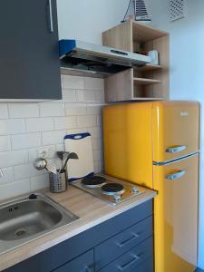 a kitchen with a yellow refrigerator and a sink at Ferienwohnung am Südstrand auf Fehmarn, Hafenblick in Fehmarn