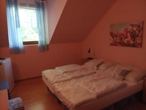 a bedroom with a bed in a room with a window at Penzion Rose in Štúrovo
