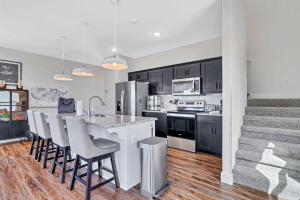 una cucina con armadi neri e un'isola cucina con sgabelli da bar di LakeCraze a Branson