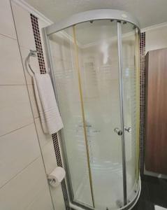 W łazience znajduje się prysznic ze szklanymi drzwiami. w obiekcie YOU Home apartment w Heraklionie