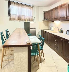 kuchnia z drewnianym stołem i krzesłami w obiekcie YOU Home apartment w Heraklionie