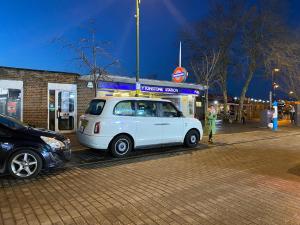 un coche blanco estacionado frente a una gasolinera en Stylish Apt London Excel Olympic close to station, en Londres