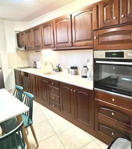 kuchnia z drewnianymi szafkami, zlewem i kuchenką w obiekcie YOU Home apartment w Heraklionie