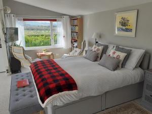 een slaapkamer met een bed met een geruite deken en een raam bij The Old School Bike Shed in Stirling