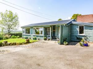 a blue house with a driveway in front of it at The Old School Bike Shed in Stirling