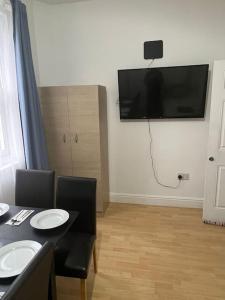 a dining room with a table and a television on the wall at 001- Lovely 3-bedroom very close to Oxford Street in London