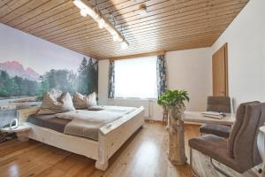 een slaapkamer met een bed en een groot raam bij Xeis NeSt in Admont
