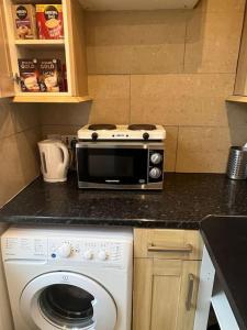 a kitchen with a microwave and a washer on a counter at 001- Lovely 3-bedroom very close to Oxford Street in London