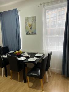 a dining room table with black chairs and a black table at 001- Lovely 3-bedroom very close to Oxford Street in London