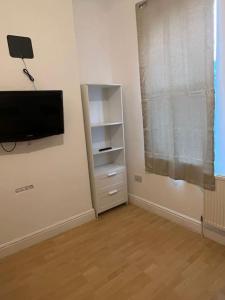 a living room with a tv and a shelf at 001- Lovely 3-bedroom very close to Oxford Street in London