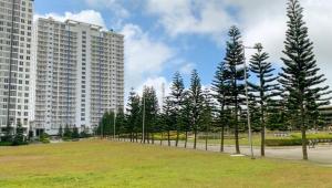 a park with trees in front of tall buildings at Affordable Staycation at COOL SUITES by SMDC Wind Residences in Tagaytay