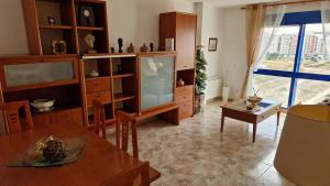 uma sala de estar com uma televisão e uma mesa de jantar em Appartement vue mer près de la plage et centre ville em Vinarós
