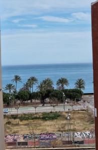 uma vista para uma praia com palmeiras e para o oceano em Appartement vue mer près de la plage et centre ville em Vinarós
