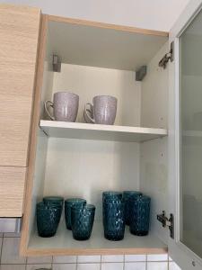 a row of blue cups sitting on a shelf at hommie apartment in Amalias