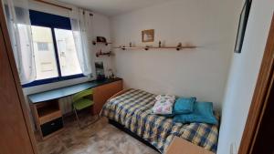 um pequeno quarto com uma cama e uma secretária em Appartement vue mer près de la plage et centre ville em Vinarós
