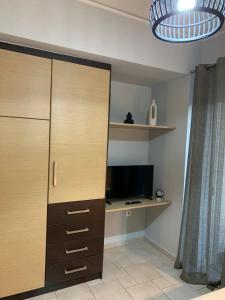 a room with a closet with a desk and a television at hommie apartment in Amalias