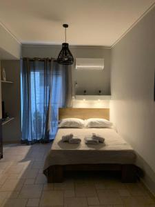 ein Schlafzimmer mit einem Bett mit zwei Handtüchern darauf in der Unterkunft hommie apartment in Amaliada