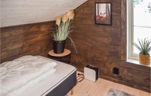 1 dormitorio con 1 cama y pared de madera en Gorgeous Home In Kongsberg With Sauna en Kongsberg