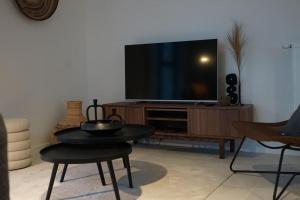 een woonkamer met een televisie en een tafel en stoelen bij Luxurious Appartment on Eilandje in Antwerpen