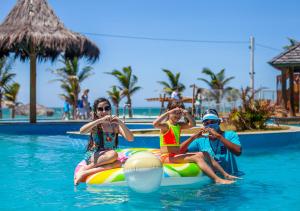 three people on a raft in the water at a resort at The Coral Beach Resort by Atlantica in Trairi