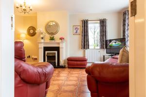 sala de estar con muebles de cuero y chimenea en Kerry Holiday Homes at the Killarney Holiday Village, en Killarney