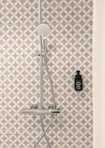 um chuveiro na casa de banho com uma parede de azulejos em Hotel-Weingut Bernard em Sulzfeld am Main