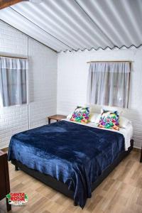 a bedroom with a bed with blue sheets and pillows at Finca Agroturística Santa Rosa in Gigante