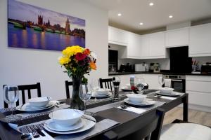 a dining room table with a vase of flowers on it at Redwood in Longton