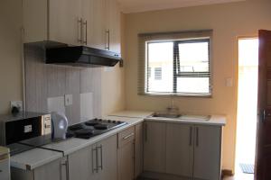 a kitchen with a sink and a stove top oven at ONESI Guest House in Maseru