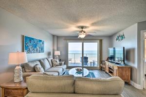 a living room with a couch and a tv at Oceanfront Condo Rental Near Daytona Speedway in Ormond Beach