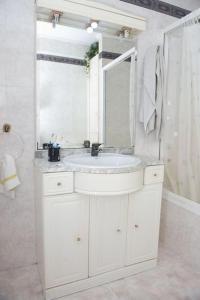 bagno bianco con lavandino e specchio di Apartamento acogedor en pleno corazón de Urdaibai a Guernica y Luno