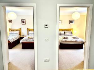 een spiegel in een kamer met 2 bedden bij Central Spacious 2 Bed 2 Bath, Free WiFi & Parking, Park View in Orkney