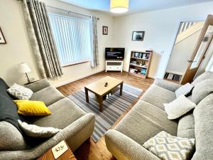 een woonkamer met een bank en een tafel bij Central Spacious 2 Bed 2 Bath, Free WiFi & Parking, Park View in Orkney