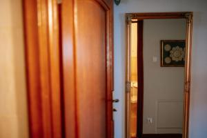 a wooden door leading to a hallway with a mirror at Corner Pokoje in Zamość