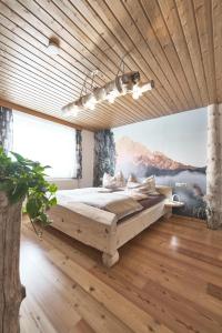 um quarto com uma cama grande e um tecto em madeira em Xeis NeSt em Admont