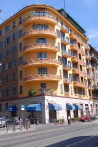 un grande edificio giallo sul lato di una strada di Roma Naif Rooms a Roma