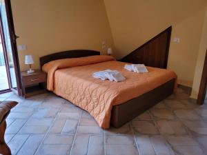 1 dormitorio con 1 cama con 2 toallas en ALLOGGIO TURISTICO MAGNIFICO ALESSANDRO VALLE BERNARDO 04025 LENOLA LT CIR 19063 nei pressi di 04022 FONDI LT en Lenola