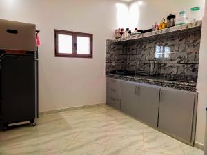 a kitchen with a black and white wall at Résidence America in Dakhla