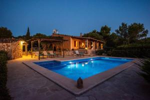 a swimming pool in front of a house at night at Finca Ca'n Tomeu in Ses Salines +13 photos