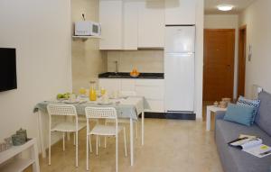 Il comprend une cuisine et un salon avec une table et des chaises. dans l'établissement MARISMA DE A LANZADA, à Sanxenxo
