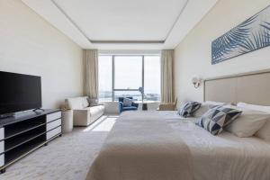 a hotel room with a large bed and a television at Palm Tower St. Regis Amazing view high-end Studio in Dubai +21 photos