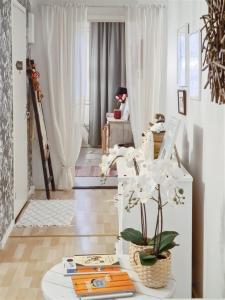 ein Wohnzimmer mit einem Tisch mit weißen Blumen darauf in der Unterkunft Casa Merikotilo merellisessä Meriraumassa. in Rauma