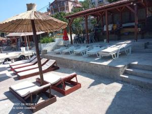 a group of lounge chairs and an umbrella at Apartments Klakor PS in Tivat