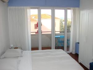 a bedroom with a white bed and a large window at ACCI Cannes Les Yuccas in Cannes