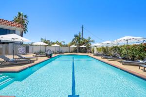 a swimming pool with chairs and umbrellas at Casablanca Inn in San Clemente